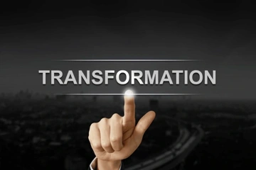 A hand pointing at the word 'TRANSFORMATION' against a dark background.